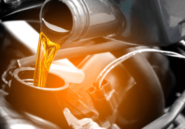Engine oil being poured from a bottle into the car engine