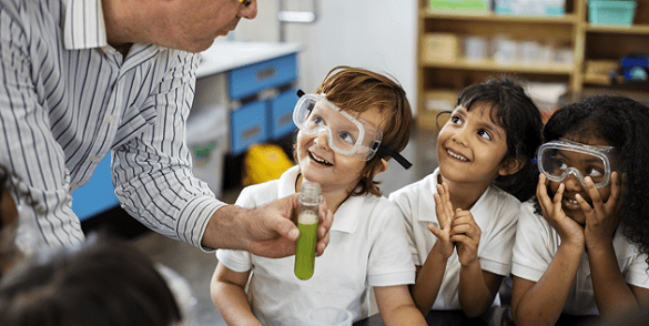 Teacher with school children, holding a test tube